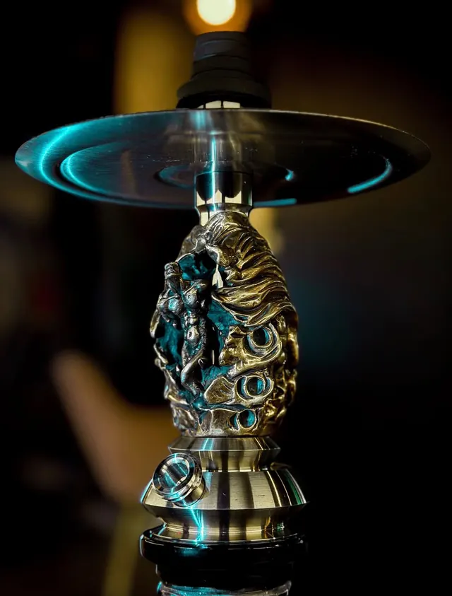 Detalle de latón labrado bajo el plato de una cachimba