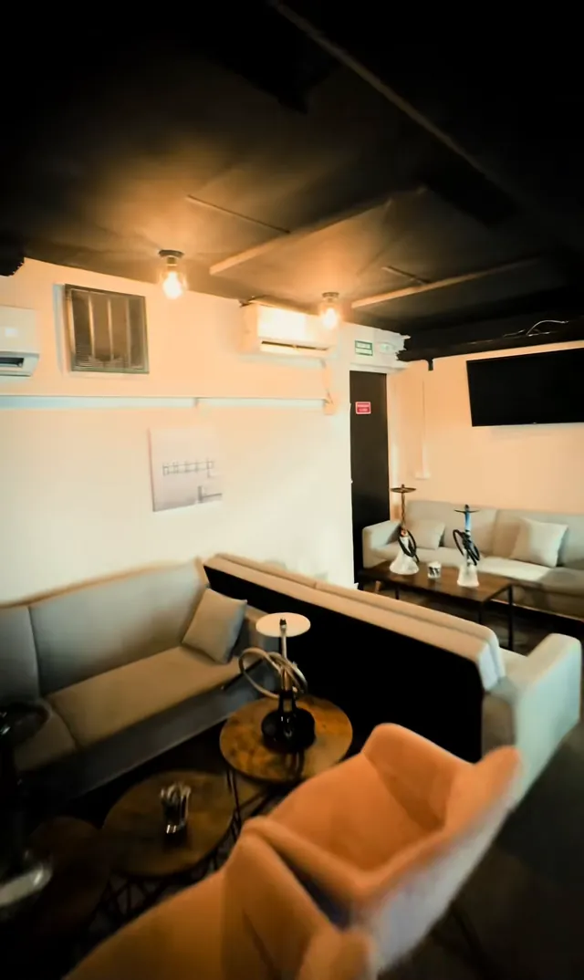 El salón con sofás blancos y una pantalla en la pared